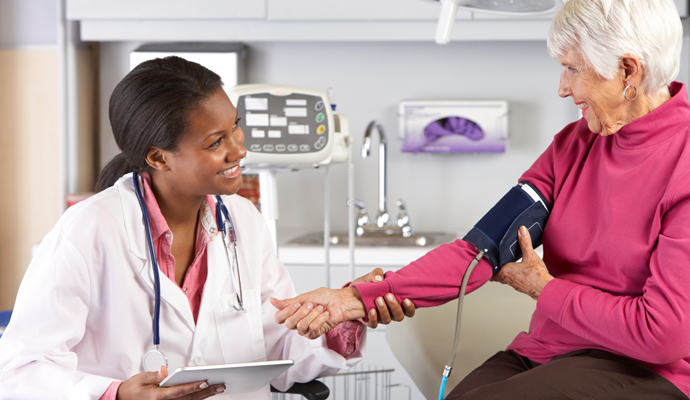 Older woman taking blood pressure with doctor